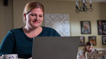 Southern New Hampshire University online college graduate Shelly Villa working at her laptop