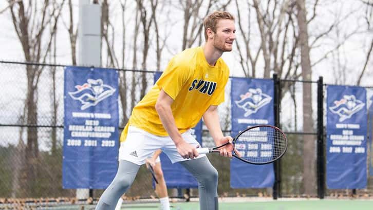 An SNHU Student playing tennis on campus
