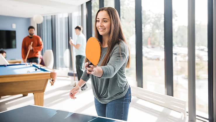 An SNHU student playing table tennis