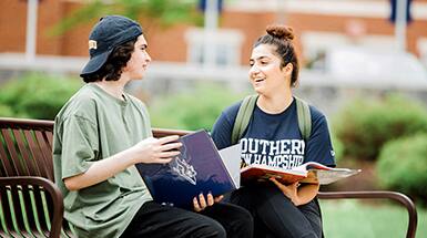 SNHU students on bench together on campus