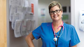 Kristina Libby, who earned her bachelor's in nursing from SNHU in 2017, wearing blue medical scrubs and a pink stethoscope around her neck.