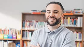 Professional standing in a classroom setting and smiling