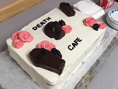 A Death Cafe cake with coffins and pink flowers