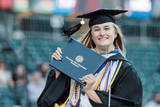 SNHU Graduate holding up diploma