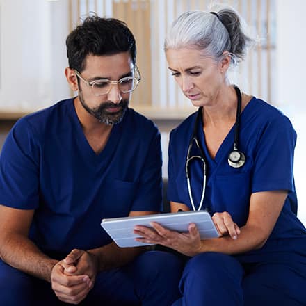 Two healthcare professionals in a Magnet hospital, reviewing a patient chart