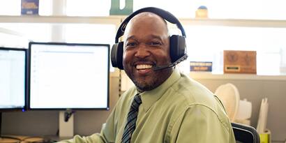 An SNHU advisor working at a desk and wearing a headset