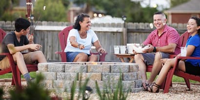 A group of people sitting around an outdoor fire pit