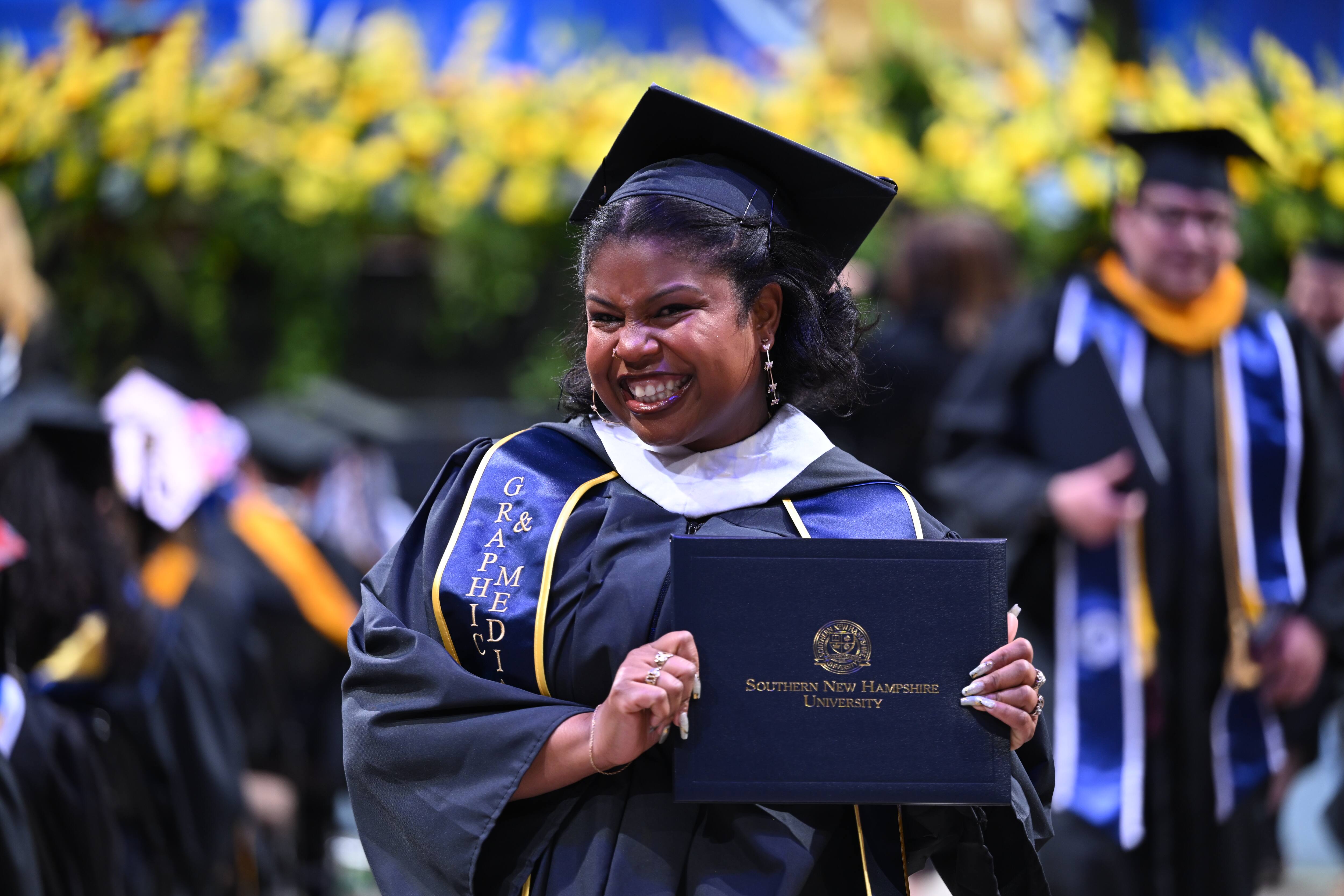 2026 Spring graduate celebrating after getting her diploma.