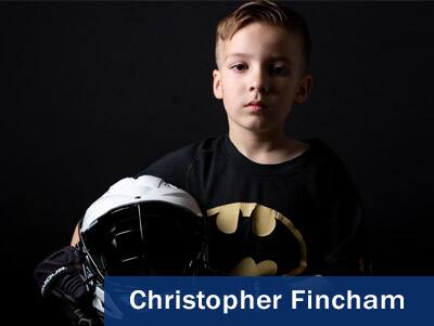 Photo of a boy holding a football helmet taken by Christopher Fincham.